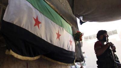 Free Syrian Army fighters near an opposition flag at their post in Aleppo's Bustan Al Qasr.