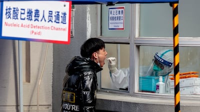 A resident gives a sample for a nucleic acid Covid-19 testing, in Shanghai. EPA