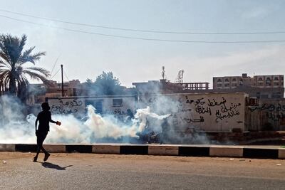 A protester throws tear gas canisters back at security forces during a rally to mark three years since the start of mass demonstrations that led to the removal of leader Omar Al Bashir, in the capital Khartoum. AFP