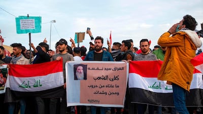 Protesters march with Iraqi national flags and a sign showing a quote from Iraq's top Shiite cleric Grand Ayatollah Ali Sistani reading in Arabic "Iraq is sovereign over itself, the people have had enough suffering from warfare, troubles, and hardships", during an anti-government demonstration, also calling for freedom of the press, in the southern Iraqi city of Basra. AFP