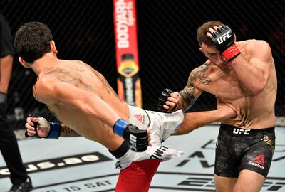 Max Holloway, left, kicks Alexander Volkanovski during their UFC Featherweight title fight at UFC 251. Zuffa LLC