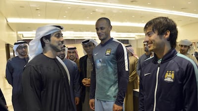 Sheikh Mansour meets with Manchester City players Vincent Kompany and David Silva after the match.