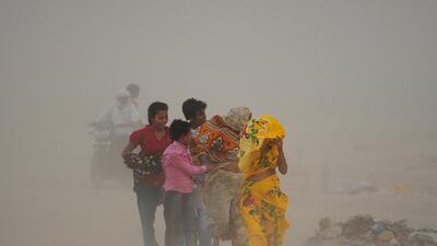Indian Hindu devotees walk through a dust storm at the Sangam, the confluence of the rivers Ganges in Allahabad, India. Sanjay Kanojia / AFP