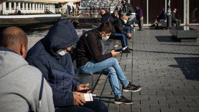 People browse smartphones at the passenger ferry pier in Istanbul, Turkey. Bloomberg