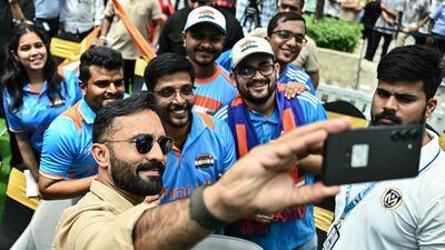 Former Indian cricketer Dinesh Karthik takes a selfie with fans at the unveiling of the ICC Women's Cricket World Cup Trophy in Bengaluru. AFP