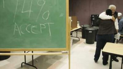Boeing machinists Heather Barstow and Paul Knebel hug each other after the union voted to accept the plane maker's four-year offer.