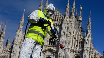 A worker wears protective gear to spray disinfectant on Piazza Duomo in Milan.AFP