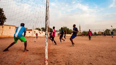 Sudanese youths play football on a dirt field in the capital Khartoum.