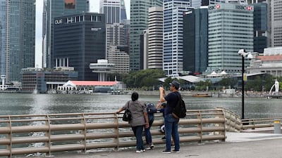 A man takes a photo as the financial business district looms in the background in Singapore. There are five digital banking licences up for grabs in the city state. AFP