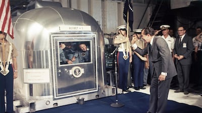 President Richard Nixon gives an "OK" sign as he greets Apollo 11 astronauts in a quarantine van aboard the USS Hornet. AP Photo
