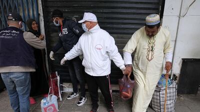 Workers distribute food aid to poor and homeless people in Algiers. AP Photo