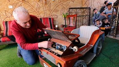 Palestinian Fawzi Al Natsheh checks his handmade electric car named "corona" in the West Bank town of Hebron. Fawzi used to work in Israel but is temporarily out of work as a result of the coronavirus COVID-19 pandemic. He collected iron pipes to make the body and decorated it with wood and painting. AFP