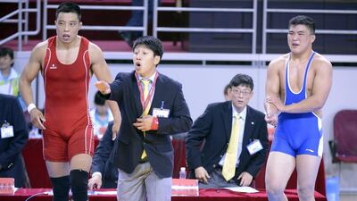 Henan wrestler Zhao Haijun, right, holds his arm after he was bitten by his opponent, Ji Rentai from Inner Mongolia, left, during their wrestling match at the 12th China National Games held in Shenyang. Fighting, biting, alleged cheating and aon-pitch protests have cast a shadow over China's National Games. AFP