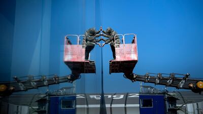 Workers apply tinting to a building's windows in the Gangneung Olympic Park as preparations for the Pyeongchang 2018 Winter Olympic Games continue. Brendan Smialowski / AFP