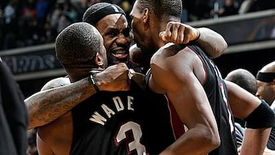 LeBron James, centre, celebrates with Dwyane Wade and Chris Bosh after Miami Heat defeated the Washington Wizards on Saturday.