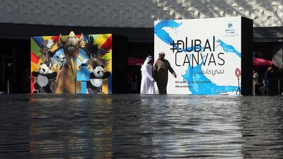 Visitors walk past the art works displayed at the Dubai 3D Art Festival at the Dubai City Walk in Dubai. Satish Kumar / The National
