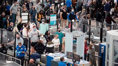 Travellers queuing at security at Denver International Airport last month. President Joe Biden will sign an executive order aimed at saving Americans time and frustration. AP