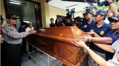 Officials push the coffin of the dead terror suspect Yuli Kartono who was killed in one of two raids in Klaten, on Thursday, June 24, 2010.