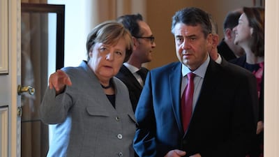 German Vice Chancellor and Foreign Minister Sigmar Gabriel (R) and German Chancellor Angela Merkel talk as they wait to be introduced to the German President during a New Year's reception at the presidential Bellevue Palace in Berlin on January 9, 2018. / AFP PHOTO / John MACDOUGALL