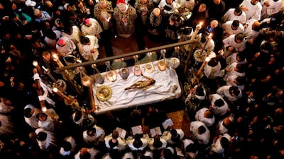 Franciscan friars pray over a statue of Jesus in the Church of the Holy Sepulchre during Good Friday, in the Old City of Jerusalem. Thomas Coex / AFP
