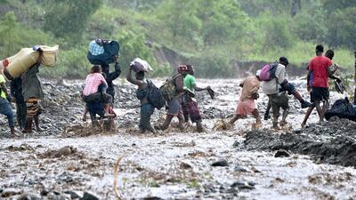 Haitians cross the river La Digue in Petit Goave where a bridge collapsed during the rains of the Hurricane Matthew, south-west of Port-au-Prince. Hector Retamal / AFP Photo