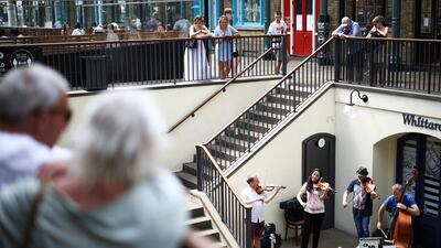 People watch a string quartet play in Covent Garden, London. Reuters