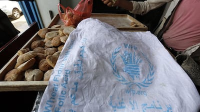 A man (R) displays bread, covered with a sack of the World Food Program (WFP), for sale at a bakery in Sana'a, Yemen, 20 June 2019. WFP has accused the Houthis of manipulating food assistance. The WFP delivers monthly rations or cash to 10.2 million people of Yemen's 26-million population. EPA