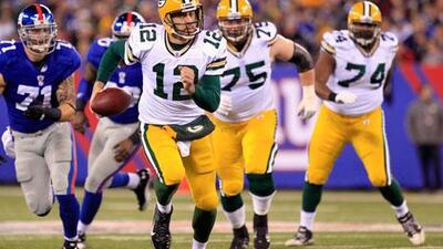 The Giants kept knocking Aaron Rodgers, centre, down, but in the end it was the Green Bay quarterback who delivered a knock-out blow.
