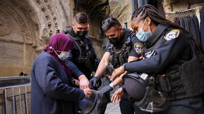 Israeli police officers check the bag of a Palestinian woman entering Al Aqsa Mosque during Ramadan last year. AFP