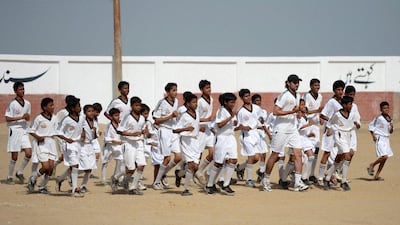 Coach Mohsin Shah (in hat), warms up with local youths at the Real Madrid Foundation academy in Karachi, Pakistan. Asif Hassan / AFP
