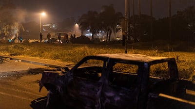 Armed community members gather at a road block in Phoenix Township, North Durban, on July 15, 2021 set up to prevent looters from reaching the community. - Armed community members and vigilante groups have stepped in to tackle unrest in South Africa, taking matters into their own hands and sometimes stoking violence as security forces struggle to restore order. Understaffed and heavily reliant on private security companies, the police was rapidly overwhelmed when riots and looting first flared last week in the southeastern province of KwaZulu-Natal (KZN), sparked by the jailing of graft-accused former president Jacob Zuma.