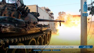 A photo released on August 2, 2018 by an Al Qaeda-affiliated agency shows a Hayat Tahrir Al Sham tank firing at Syrian troops in rural Aleppo. Ibaa News Network via AP