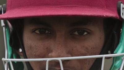 In this May 12, 2014 photo, Derick Narine, currently the top cricket player in New York City's Public School Athletic League from John Adams High School, wears a helmet as he prepares to bat in a match against Midwood High School at Marine Park in the Brooklyn borough of New York. Bebeto Matthews / AP
