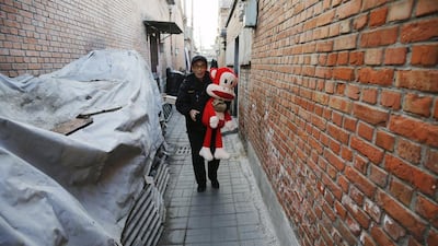 A man carries a large toy between houses in an area next to a coal power plant in Beijing during a smog-free day in the Chinese capital. Damir Sagolj / Reuters