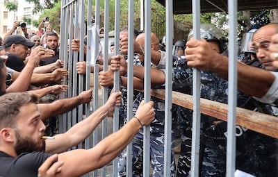 Protesters try to pull out the gate leading to the Justice Palace in Lebanon's capital Beirut on September 19, 2022, demanding the release of two people involved in a bank heist the prior week. AFP