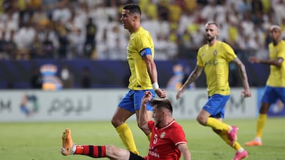 Al Nassr's Cristiano Ronaldo in action with FC Istiklol's Sodiqjon Qurbonov. Reuters
