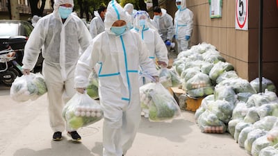 Volunteers carry daily necessities for residents in Fengxian District in eastern China's Shanghai city. AP