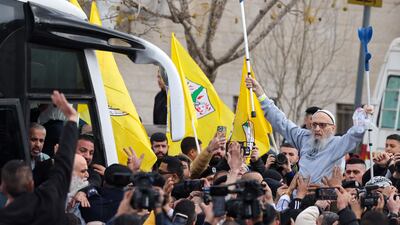 A Palestinian former detainee waves a pair of crutches in the air as he is cheered by the crowd greeting him in Ramallah. AFP