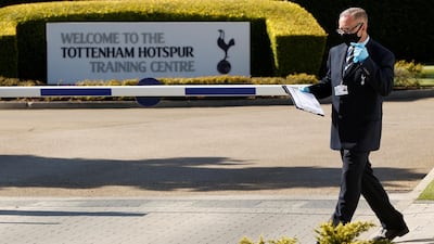 A man wearing a mask and gloves is seen at the car park entrance at Tottenham Hotspur training centre. Reuters