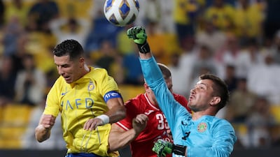 SoAl Nassr's Cristiano Ronaldo goes up for a header with FC Istiklol's Ivan Novoselec and Rustam Yatimov. Reuters