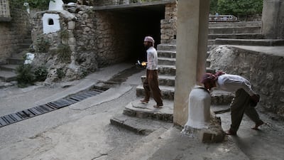 Yazidi men light candles at the Lalish temple in tribute to victims of ISIS from Kocho. AFP