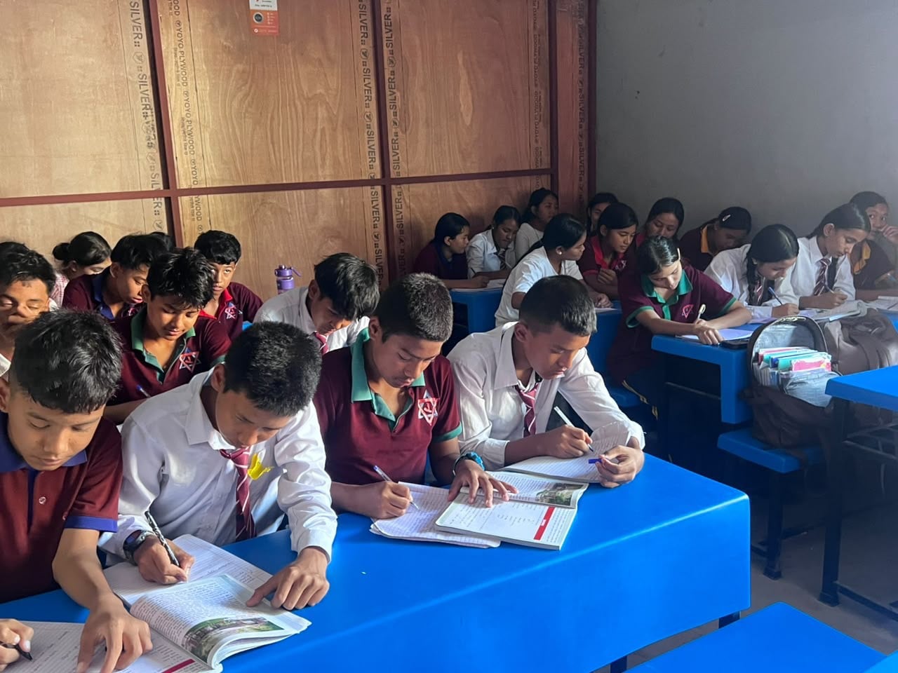 Pupils share benches and desks in temporary school facilities. Photo: Rajendra Dawadi