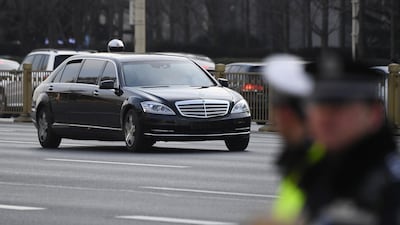 The lead limousine in the motorcade of Kim Jong-un drives past police standing guard along the main east-west boulevard of Changan in Beijing. AFP