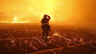 Fire photographer Tod Sudmeier gets hit with flying embers from strong winds at the Solimar brush fire that started early Saturday morning in Ventura County, California. A wildfire in Southern California burned over 1,000 acres of land, forced the closure of parts of two major highways and led to evacuations, fire officials said. Gene Blevins / Reuters