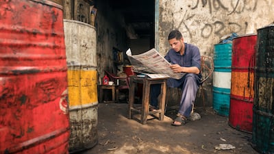 A car mechanic reads a newspaper during a break in Sahiwal, Pakistan. Courtesy Sohail Karmani