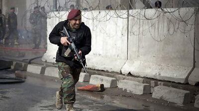 An Afghan soldier runs outside the defence ministry after a suicide bomber attacked outside the ministry, killing at least nine Afghan civilians. Anja Niedringhaus / AP Photo