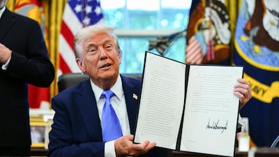 US President Donald Trump holds a signed executive order authorising new visa rules for foreign workers. Bloomberg