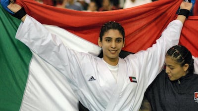 Sheikha Maitha bint Mohammed bin Rashid carries her national flag after winning the single category of the Seventh GCC self-defence Championship in Bahrain in 2003. AFP