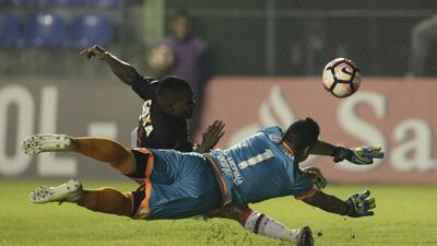 Nikao, top, midfielder of Brazil’s Atletico Paranaense fights for the ball with goalkeeper Bernardo Medina of Paraguay’s Deportivo Capiataduring a Copa Libertadores soccer match in Capiata, Paraguay. Jorge Saenz / AP