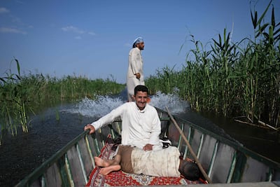 A boy rests as fishermen sail their boat through the Hawizeh Marshes in Maysan province. AFP